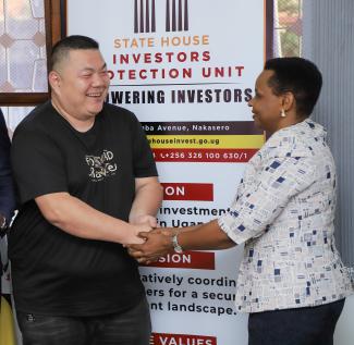 Investor Zeng Rong Yao, the CEO of Bisu Industries Limited takes a photo moment with Col. Edith Nakalema
